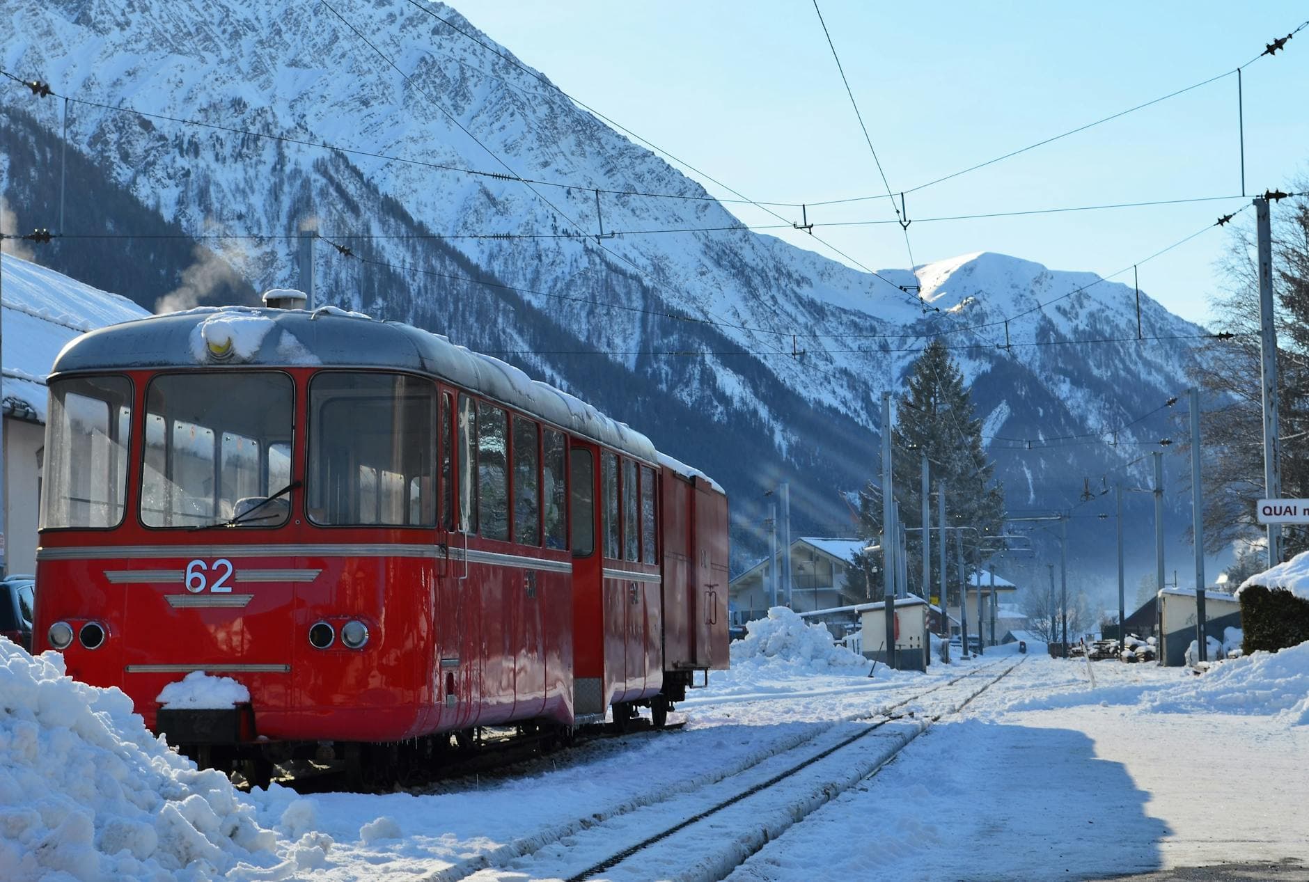 Red train in snowy Chamonix-Mont-Blanc, showcasing winter travel in the French Alps.